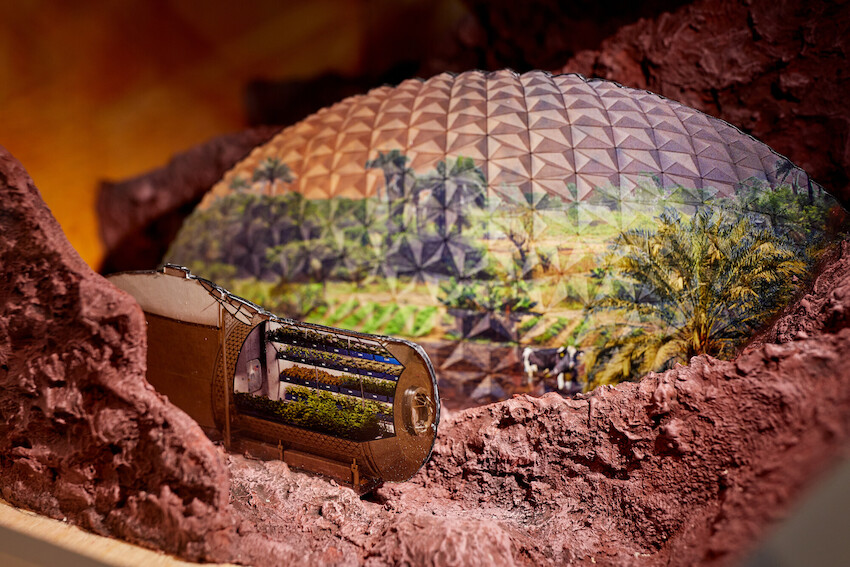 Ein Modell von einer zukünftigen Besiedelung des Mars. Eine riesige Kuppel, darunter sind Pflanzen zu sehen. 